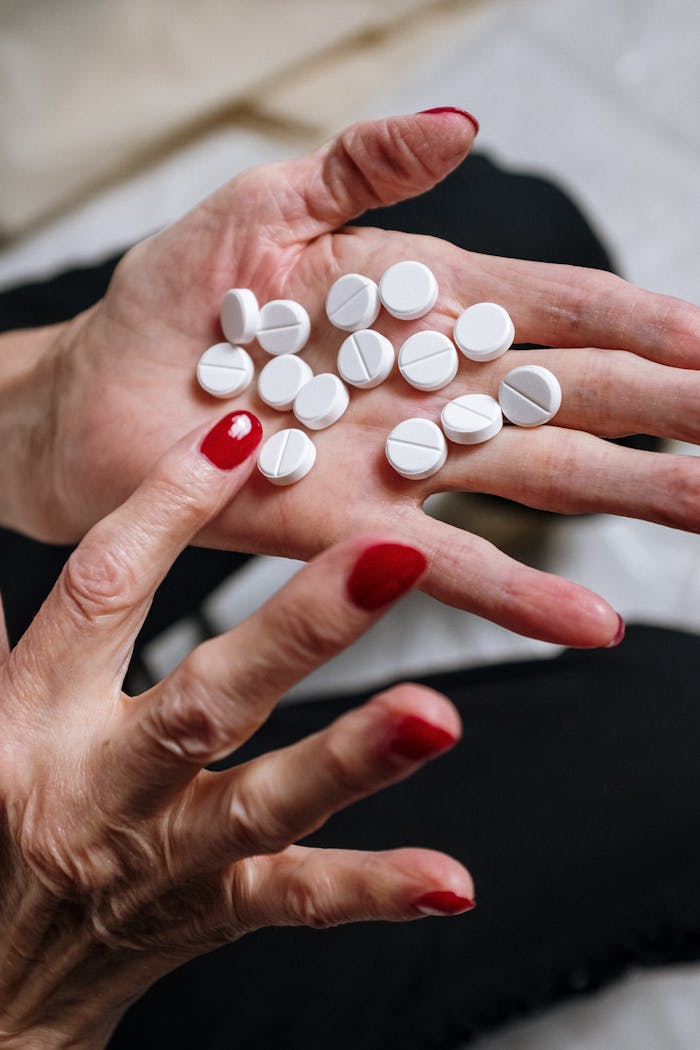 services-img A woman's hand with red nail polish holding white pills, indicating a medical or health theme.